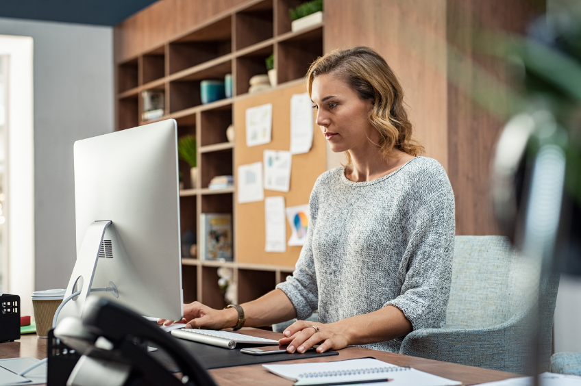 woman sitting at her desk working on her computer paying attention to email structure